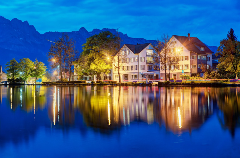 A group of houses next to a body of water</p>
<p>Description automatically generated with low confidence
