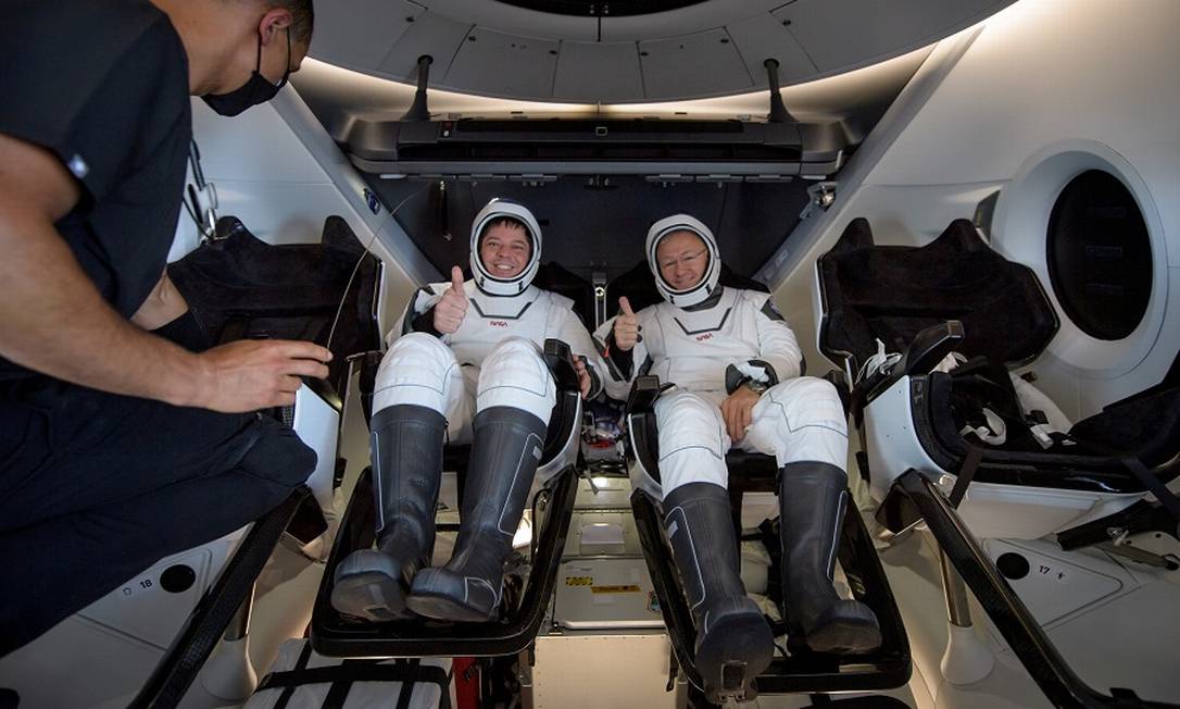 Os astronautas Robert Behnken e Douglas Hurley dentro da nave Crew Dragon, da Space X, após retornarem de voo em 2020 Foto: Bill Ingalls / NASA via REUTERS