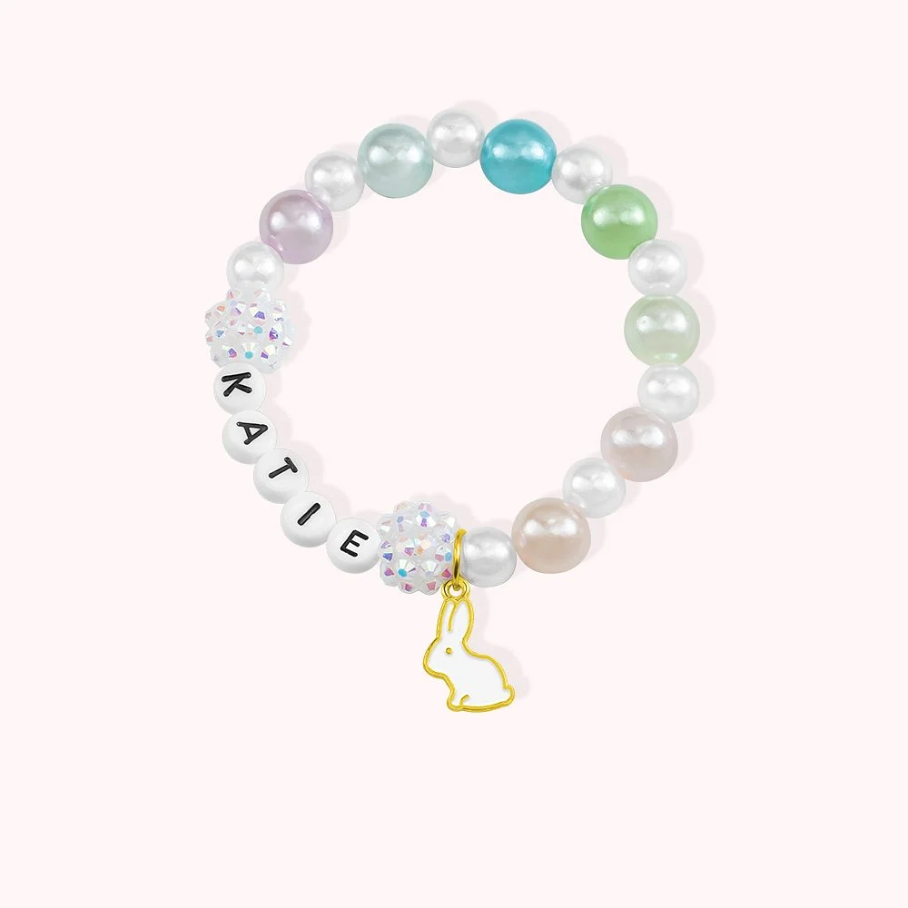 bracelet en perles, personnalisé d’un prénom et décoré d’un lapin couleur or. 