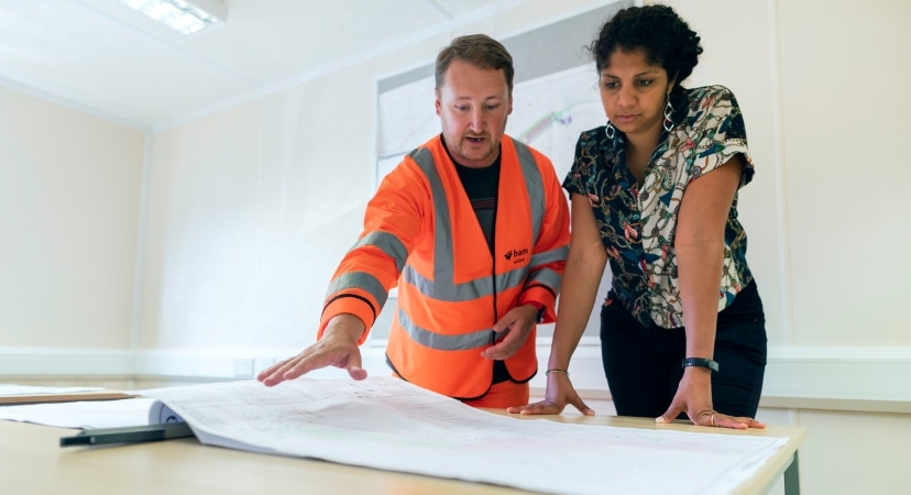 a woman going over the blueprints for her custom home with the contractor