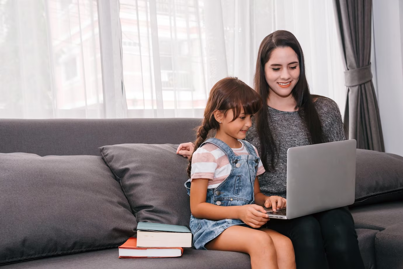 A daughter studying at home with her mother