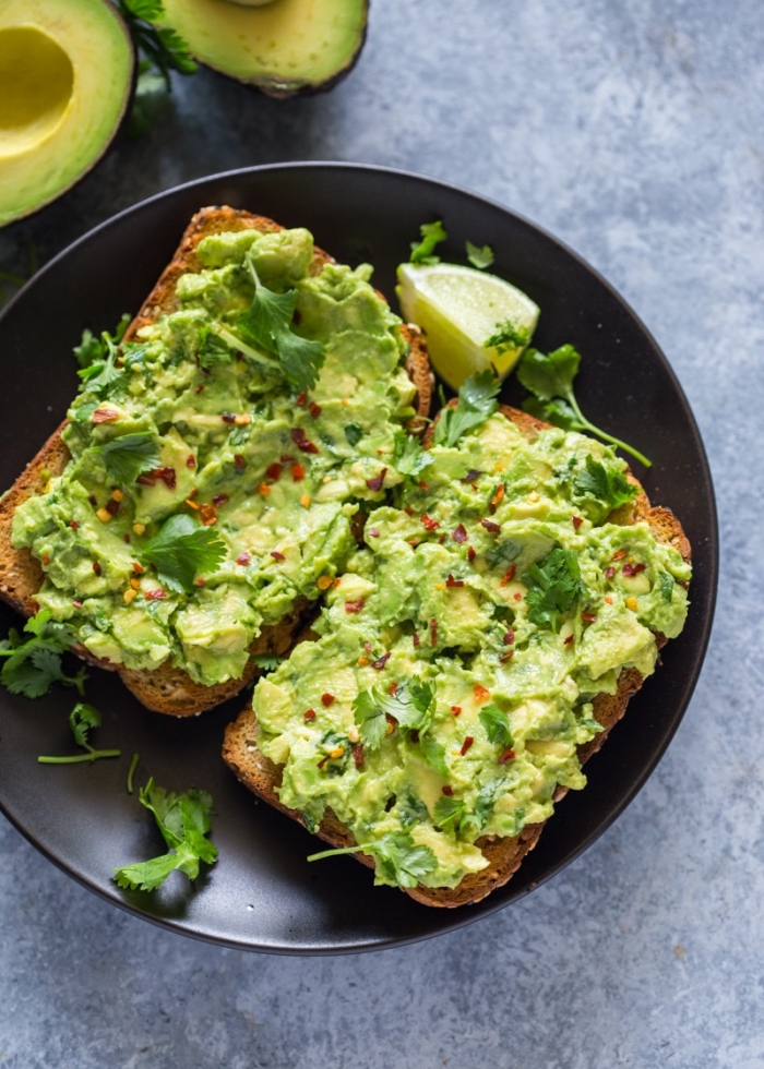 brunch ideen, toasts mit avocado und eiern garniert mit chilli und petersillie, gesund essen