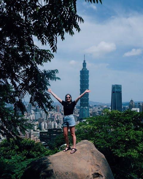 A person standing on a rock with a city in the background

Description automatically generated with medium confidence