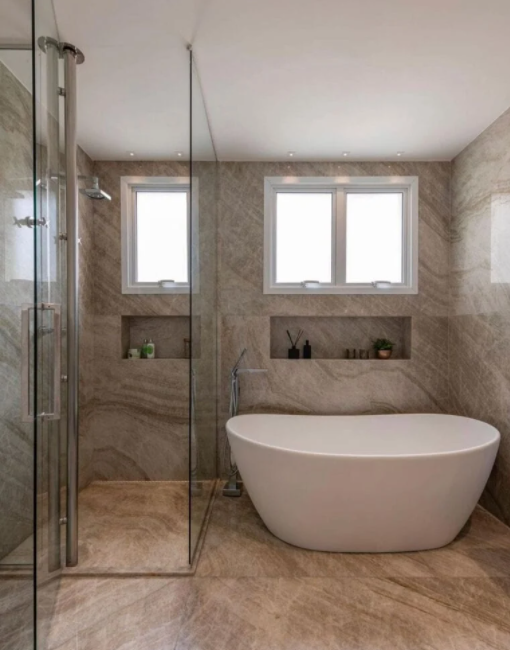 Banheiros com banheiras: Banheiro pequeno com banheira de imersão branca, revestimento na parede e piso em tom neutro e box de vidro