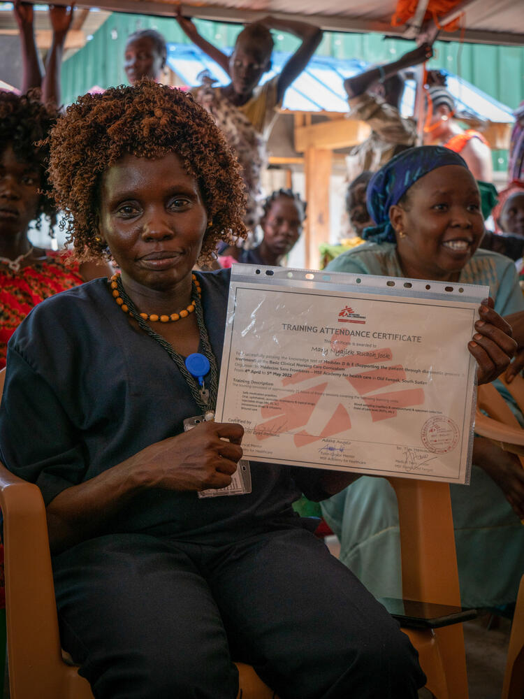 Nursing student Mary Nyajiek holds her certificate at the graduation ceremony
