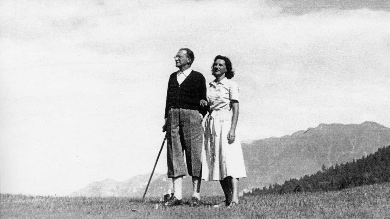 A person and person standing in a field with mountains in the background

Description automatically generated with medium confidence