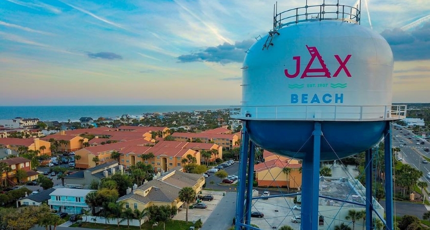 An aerial view of the Jacksonville Beach water tower with the city and ocean in the background.