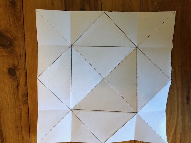Paper opened out with next square drawn on new folds.