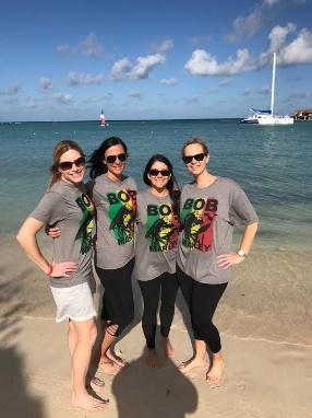 A group of people posing for a photo on a beach

Description automatically generated