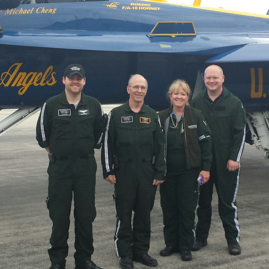 Flight paramedic colleagues stand outside of an emergency medical helicopter