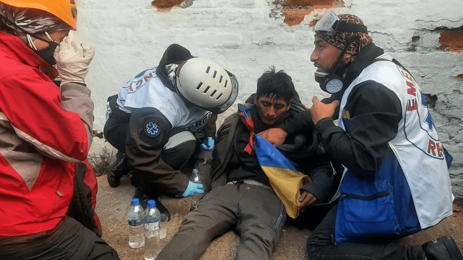 A wounded striker is slumped on the floor and tended two by emergency resuce volunteers