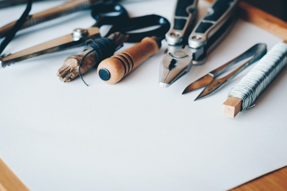 A set of tools including pliers and scissors sit on top of a white table top. Image for "How to make time for your passions when family is full on"