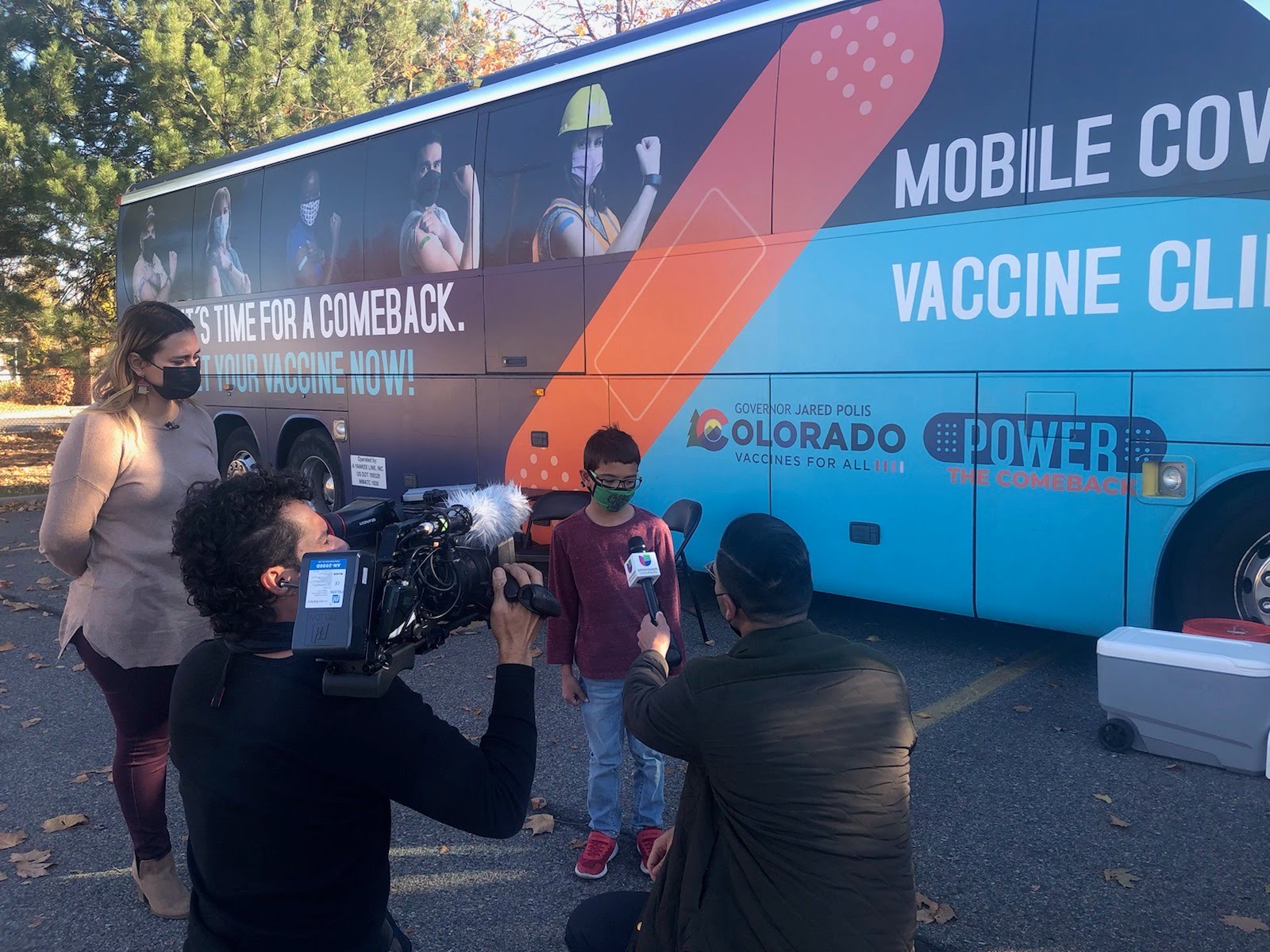 Young boy being interviewed next to a vaccine bus.