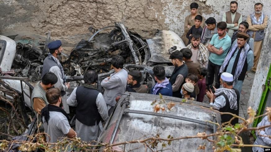 Cư dân người Afghanistan và gia đình nạn nhân tụ tập quanh chiếc xe bị hư hại một ngày sau cuộc không kích bằng drone của Mỹ ở Kabul, ngày 30 tháng 8, 2021.