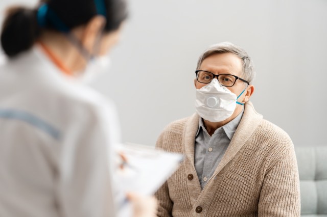 Doctor and senior man wearing facemasks during coronavirus and flu outbreak