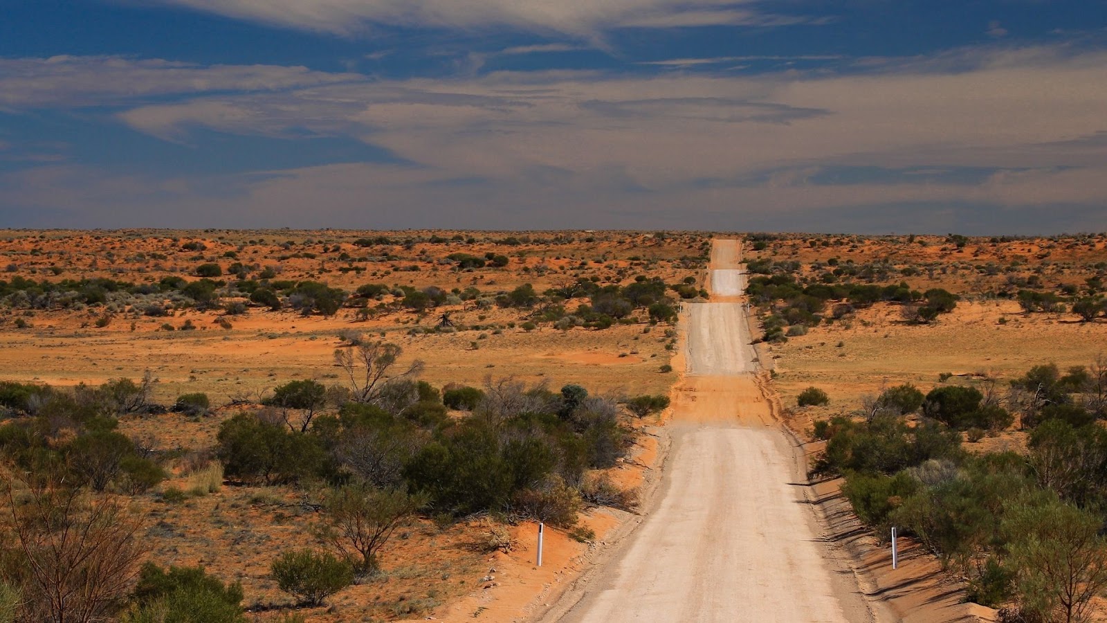 A dust road stretching to the horizon across the Australian Outback