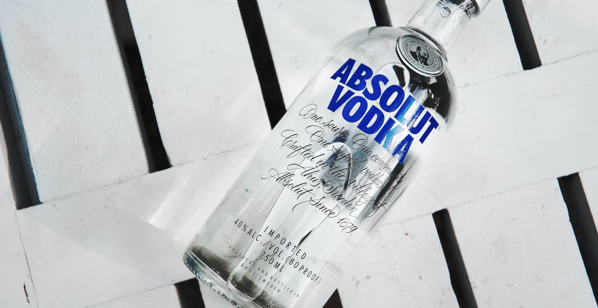 Absolut Vodka whatsapp marketing strategy | A bottle of Absolut Vodka on white wooden surface. 