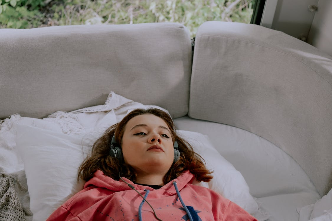 sleepy woman lying on the wearing headphones
