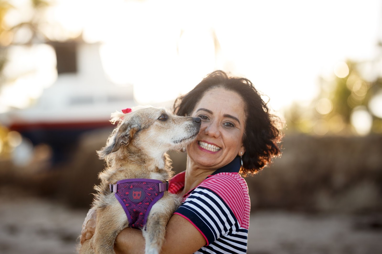 Mulher veterinária com cachorro no colo sorrindo 