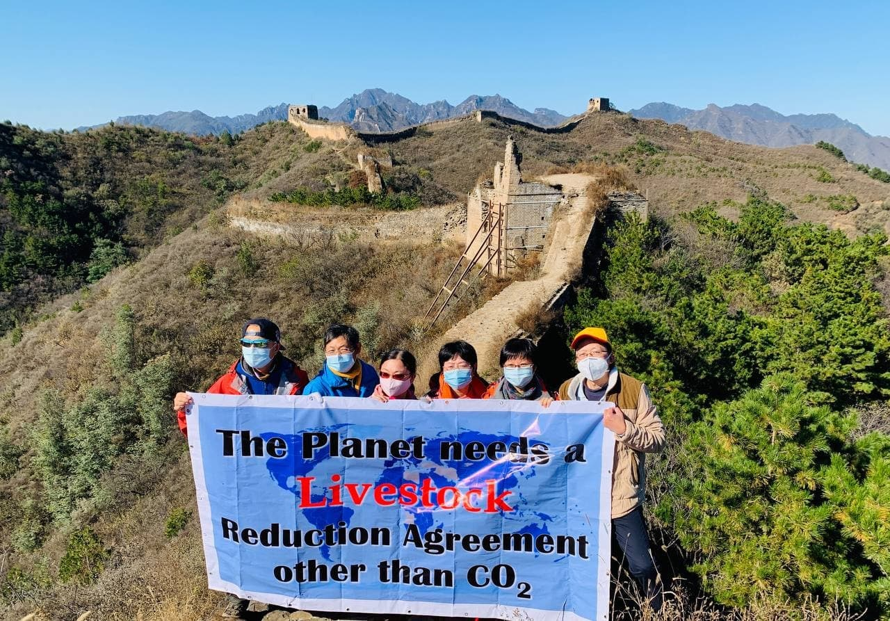 6 chinese rebels hold a banner on the great wall.