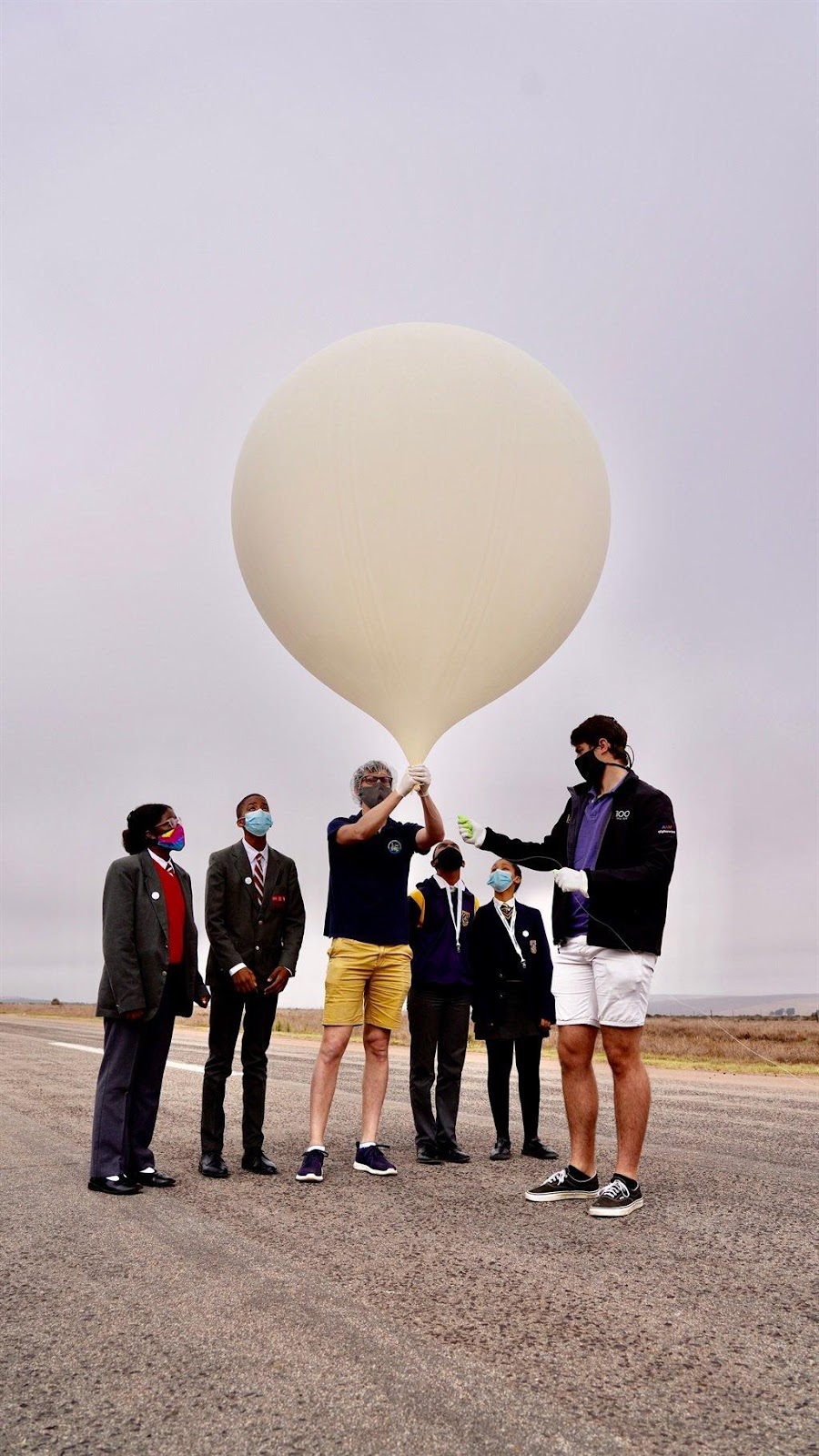 A group of people holding a balloon

Description automatically generated