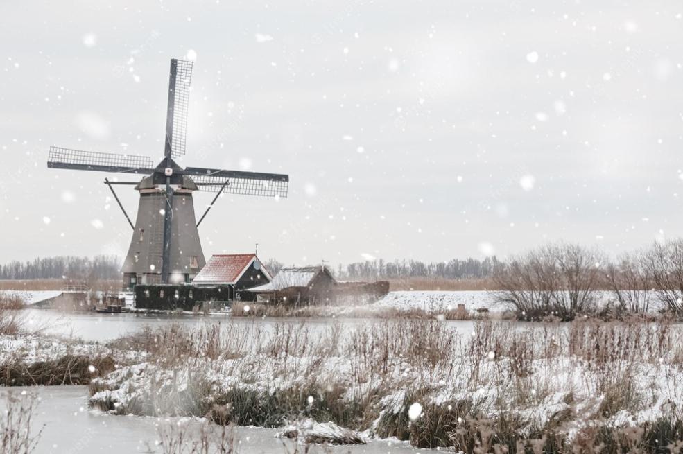windmill and house near river in snowy weather