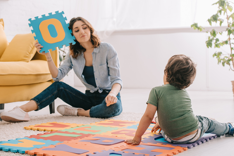 Mom using foam letters to teach verbs for kids
