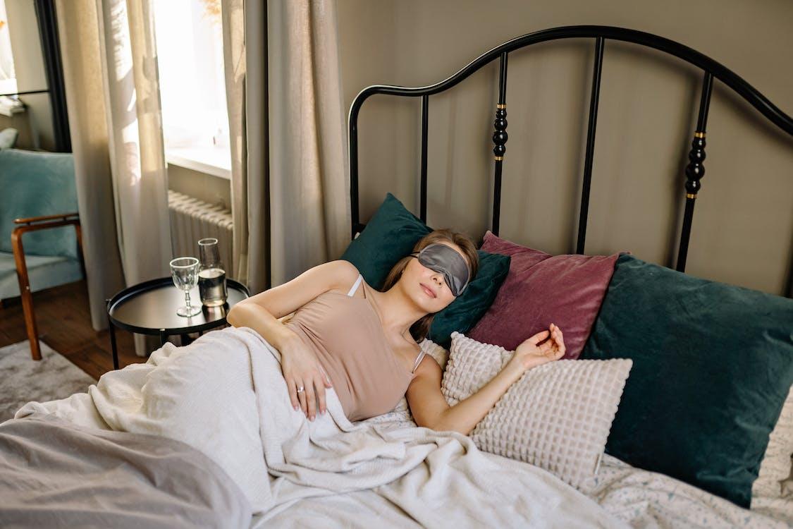 Free A Woman Wearing Eye Mask Sleeping on the Bed Stock Photo