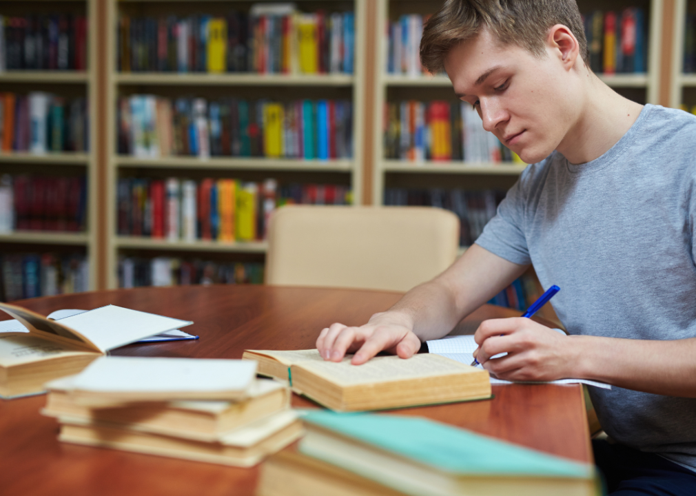 A student studying at a library desk.