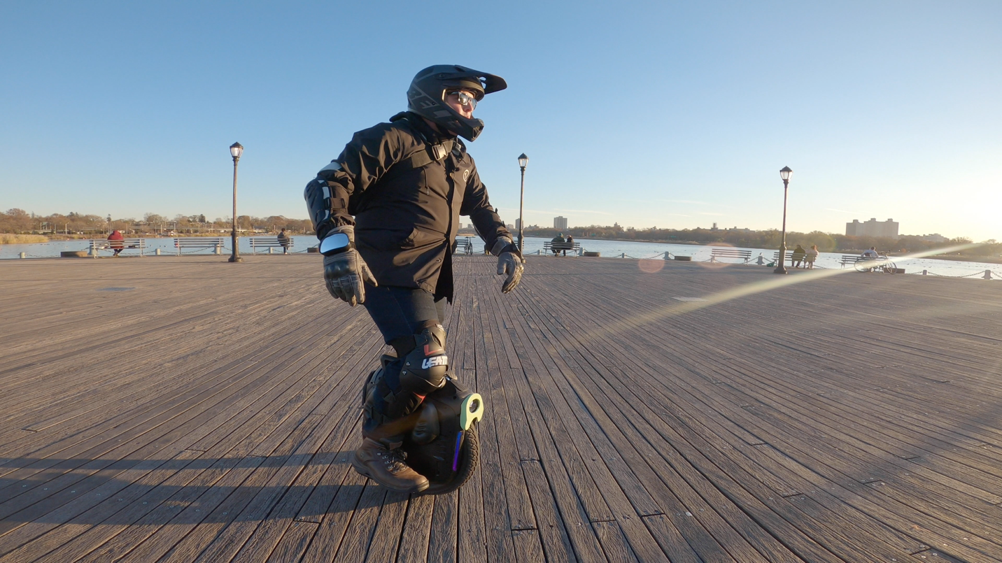 A person riding a skateboard up the side of a road

Description automatically generated