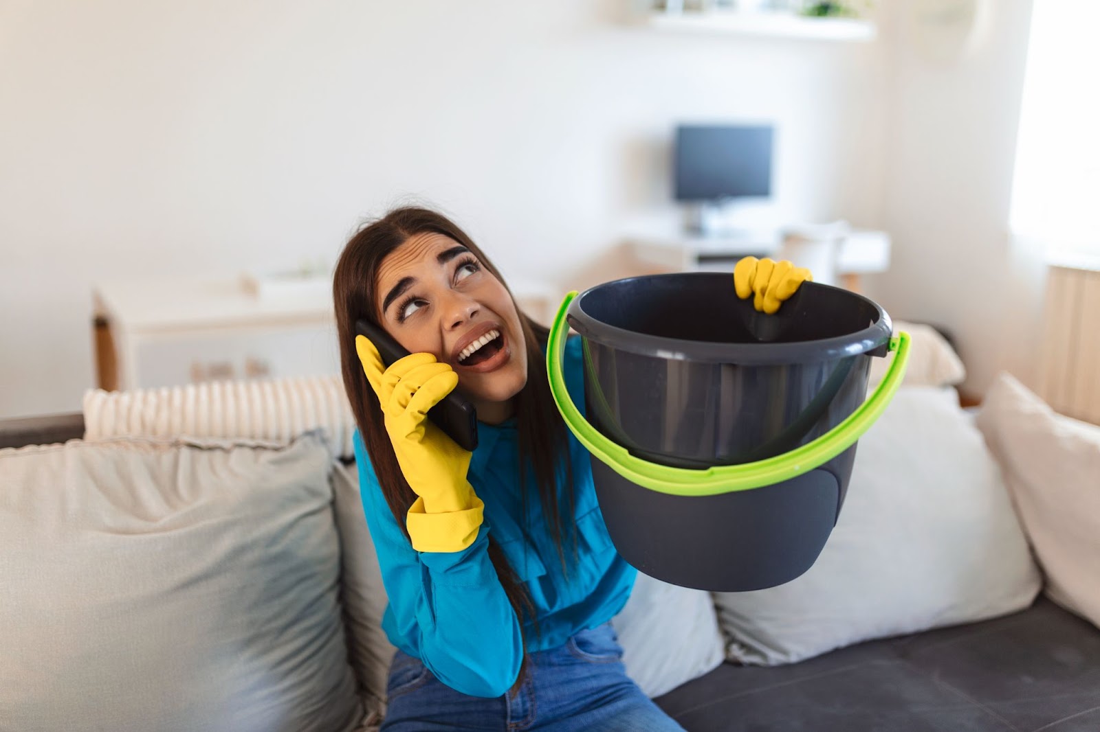 A woman holding a bucket and a phone