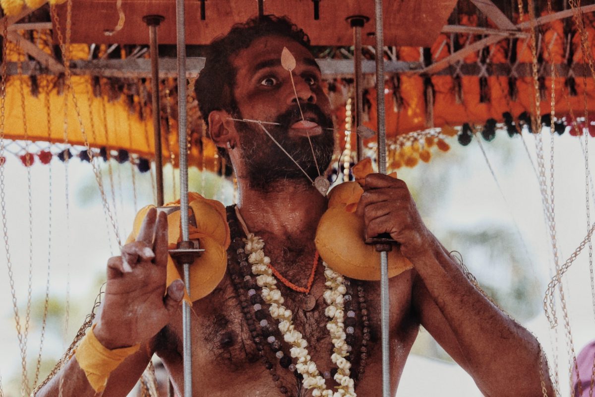 A Hindu devotee dances with a heavy Kadavi balanced atop his shoulders