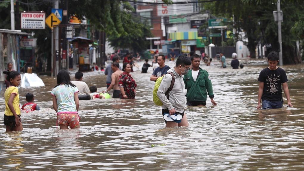 Un grupo de personas en una calle con agua

Descripción generada automáticamente