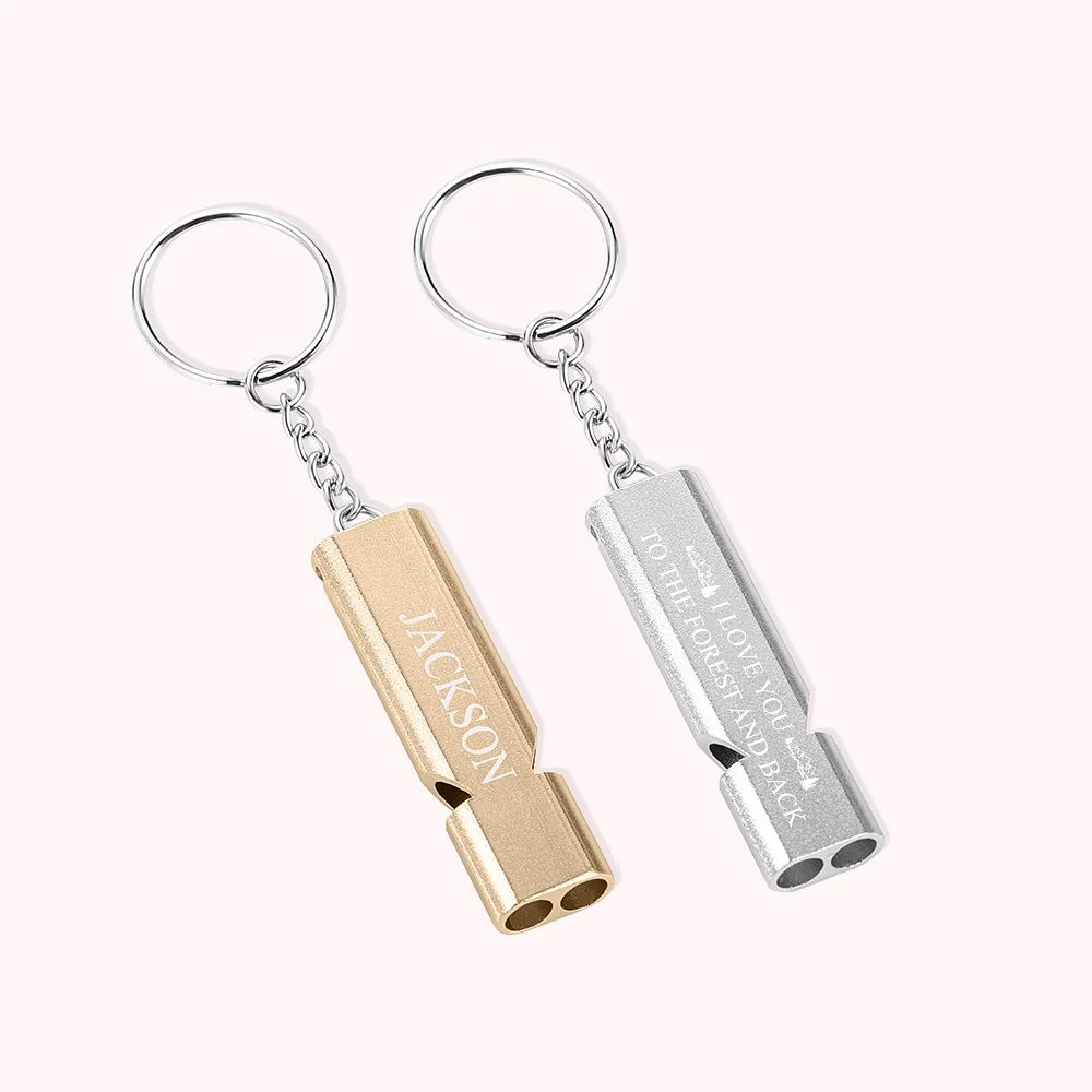 2 porte-clés en forme de sifflet, l’un en or, l’autre en argent, avec personnalisation.