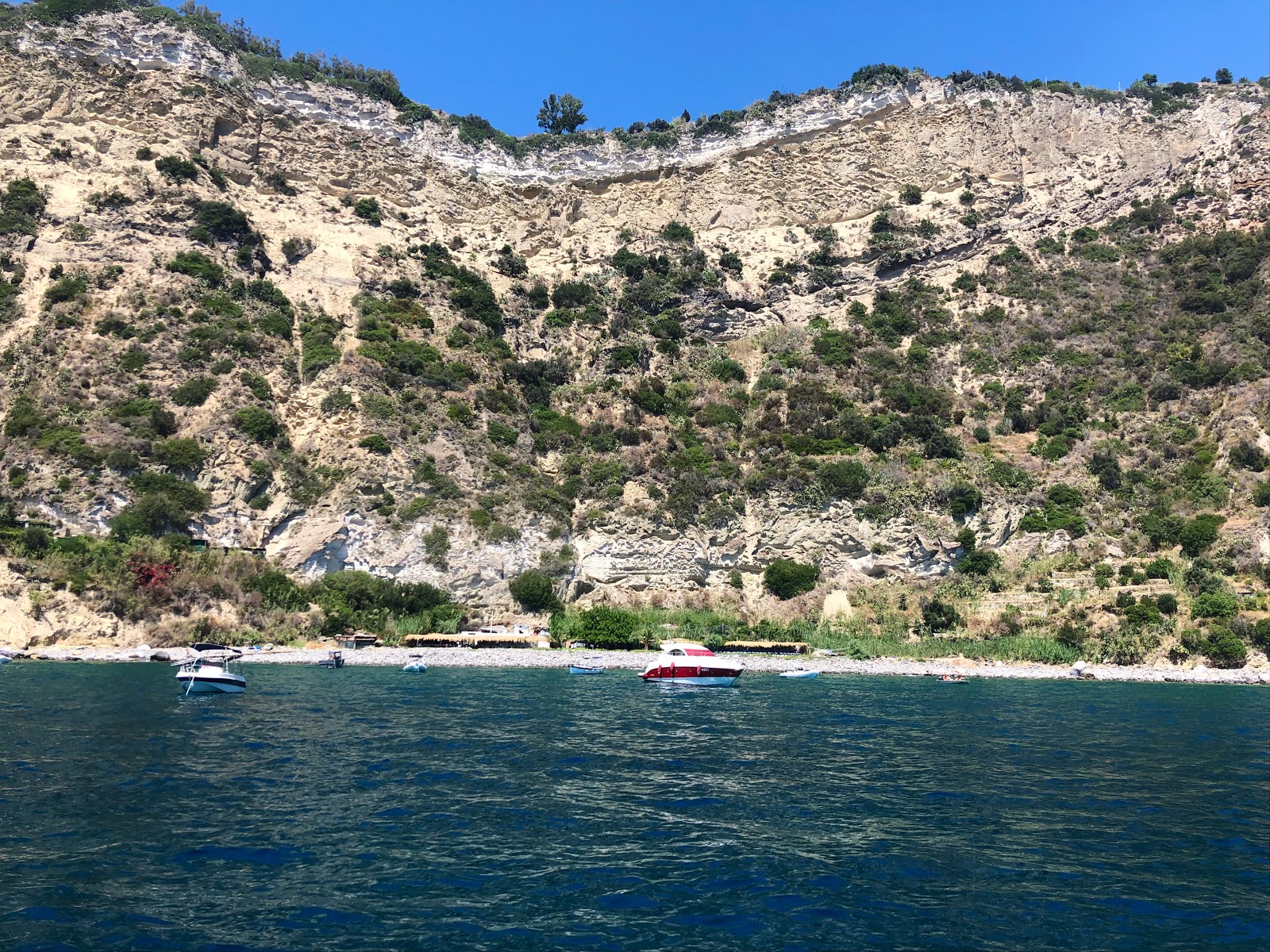 Foto af Spiaggia Scarrupata bakket op af klipperne