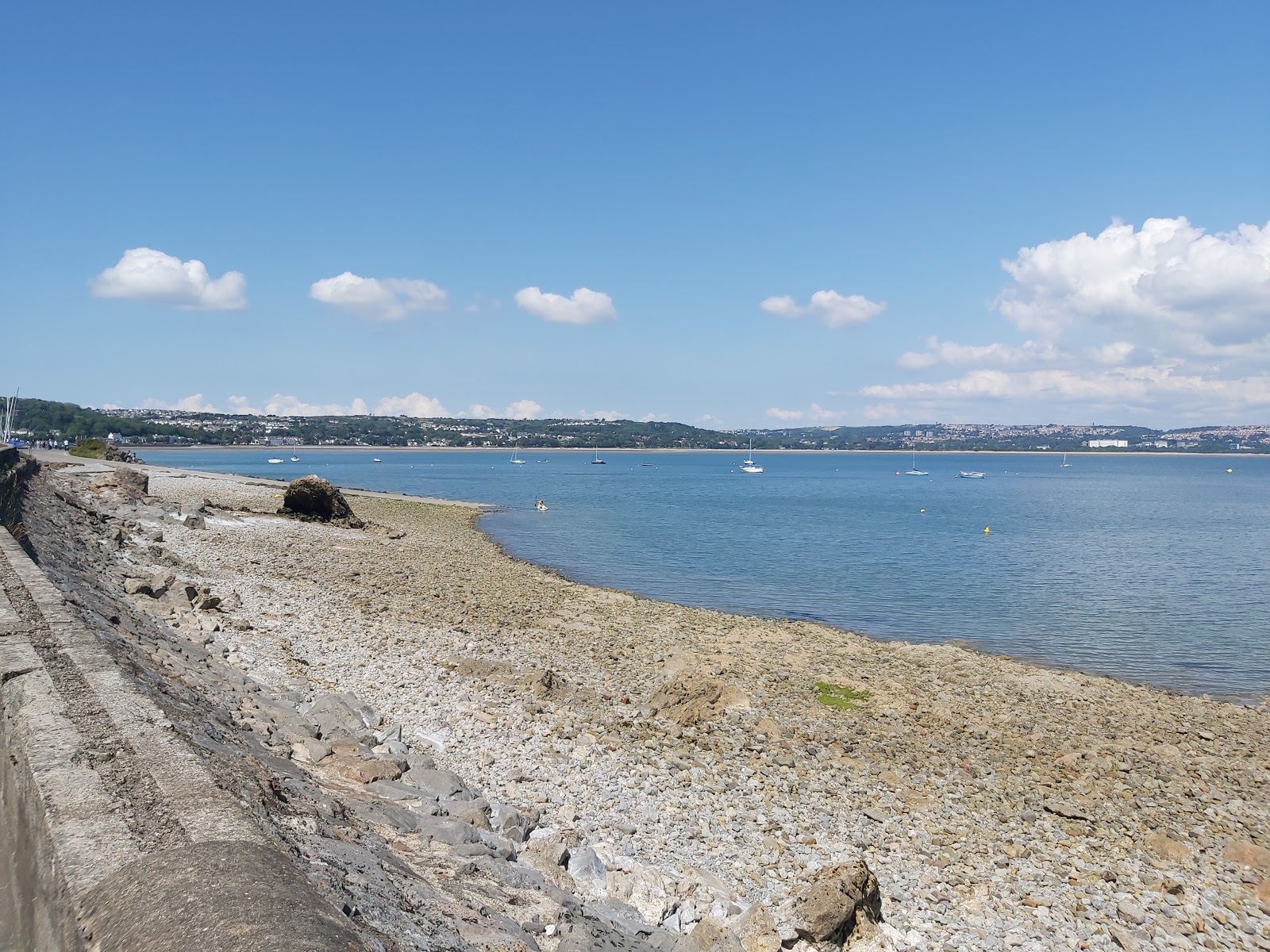 Foto di Mumbles beach con una superficie del sabbia beige e rocce