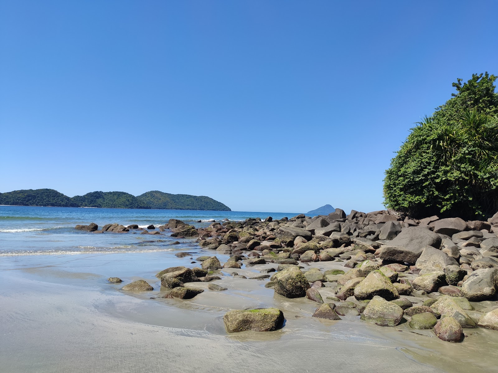 Foto af Preta da Costa do Sul Strand bakket op af klipperne