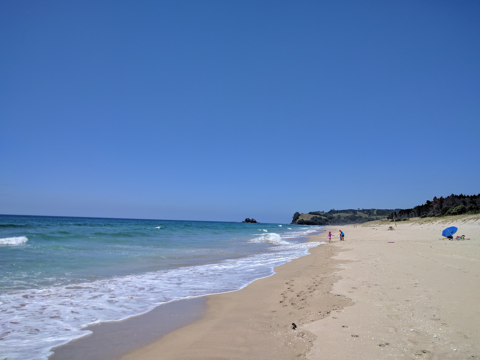 Opoutere Beach的照片 带有明亮的沙子表面