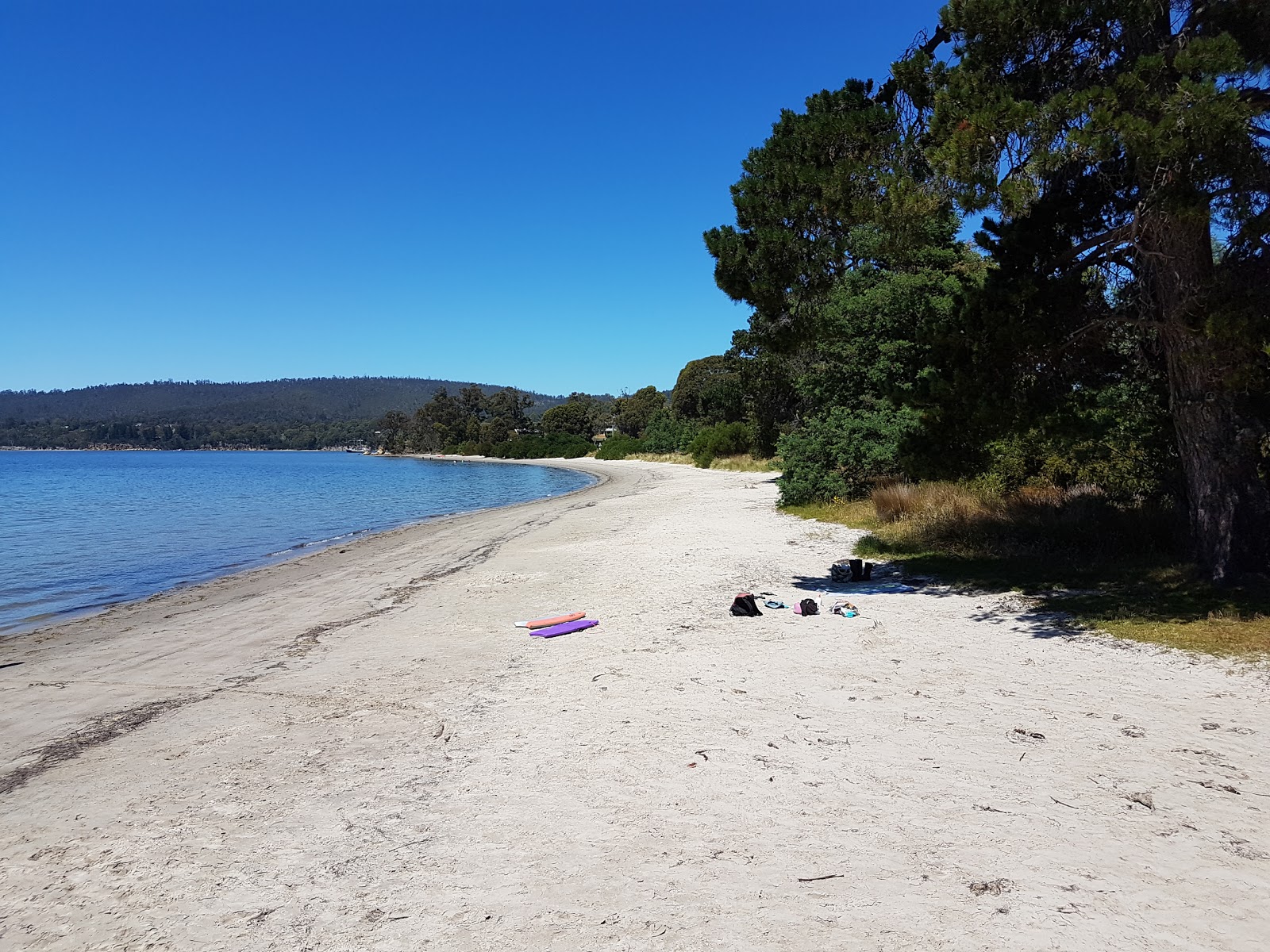 Φωτογραφία του Snug Beach με μπεζ άμμος επιφάνεια