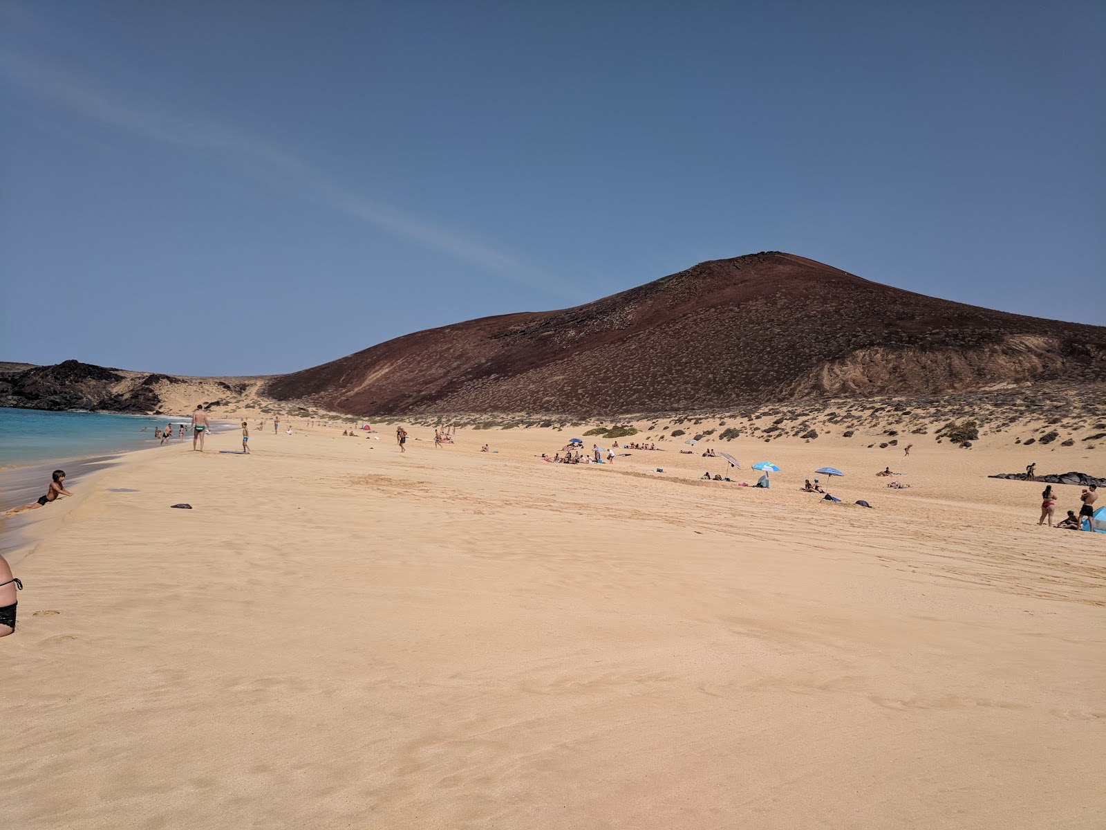 Playa de las Conchas'in fotoğrafı turkuaz saf su yüzey ile