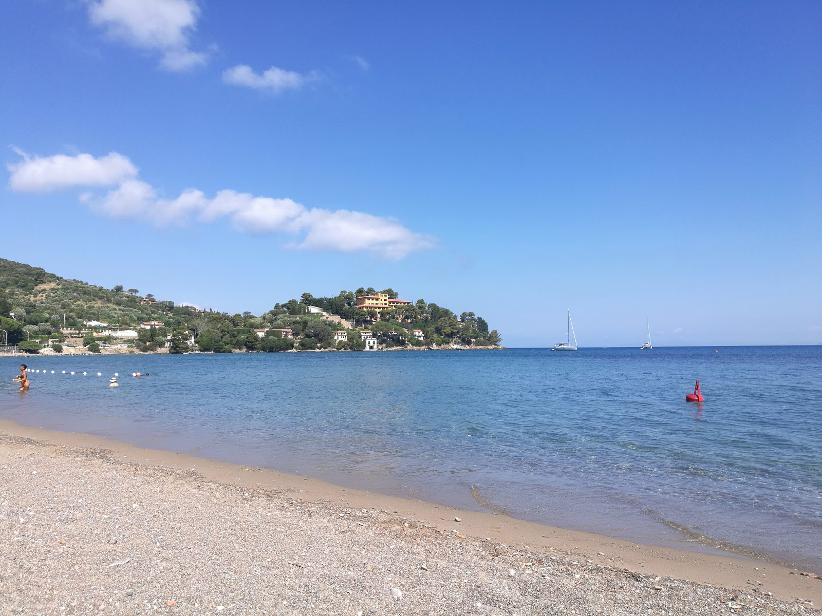 Foto av Pozzarello beach med blått vatten yta