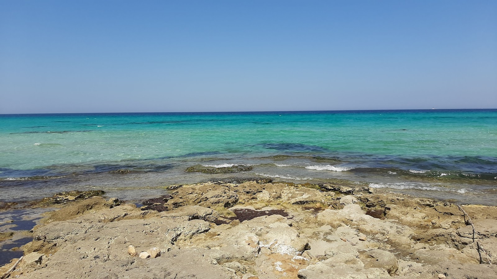 Foto von Spiaggia la Sujana mit beiger sand & steine Oberfläche