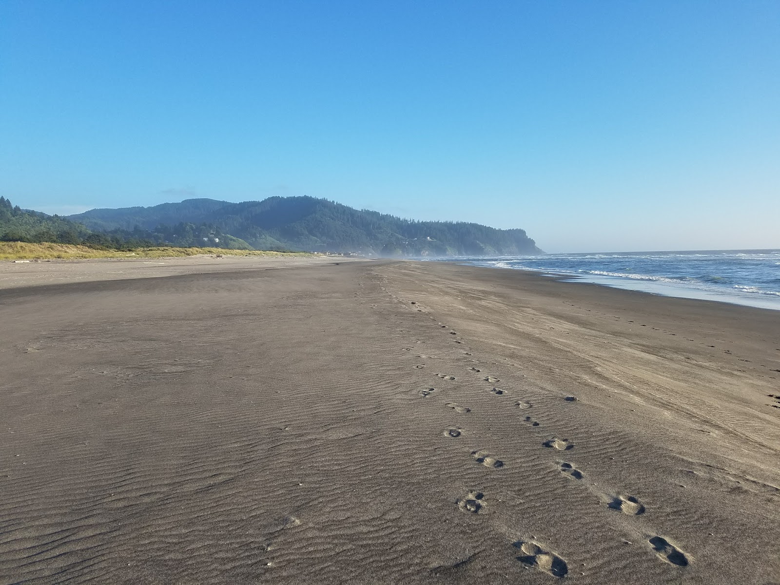 Photo of Neskowin Beach with blue pure water surface