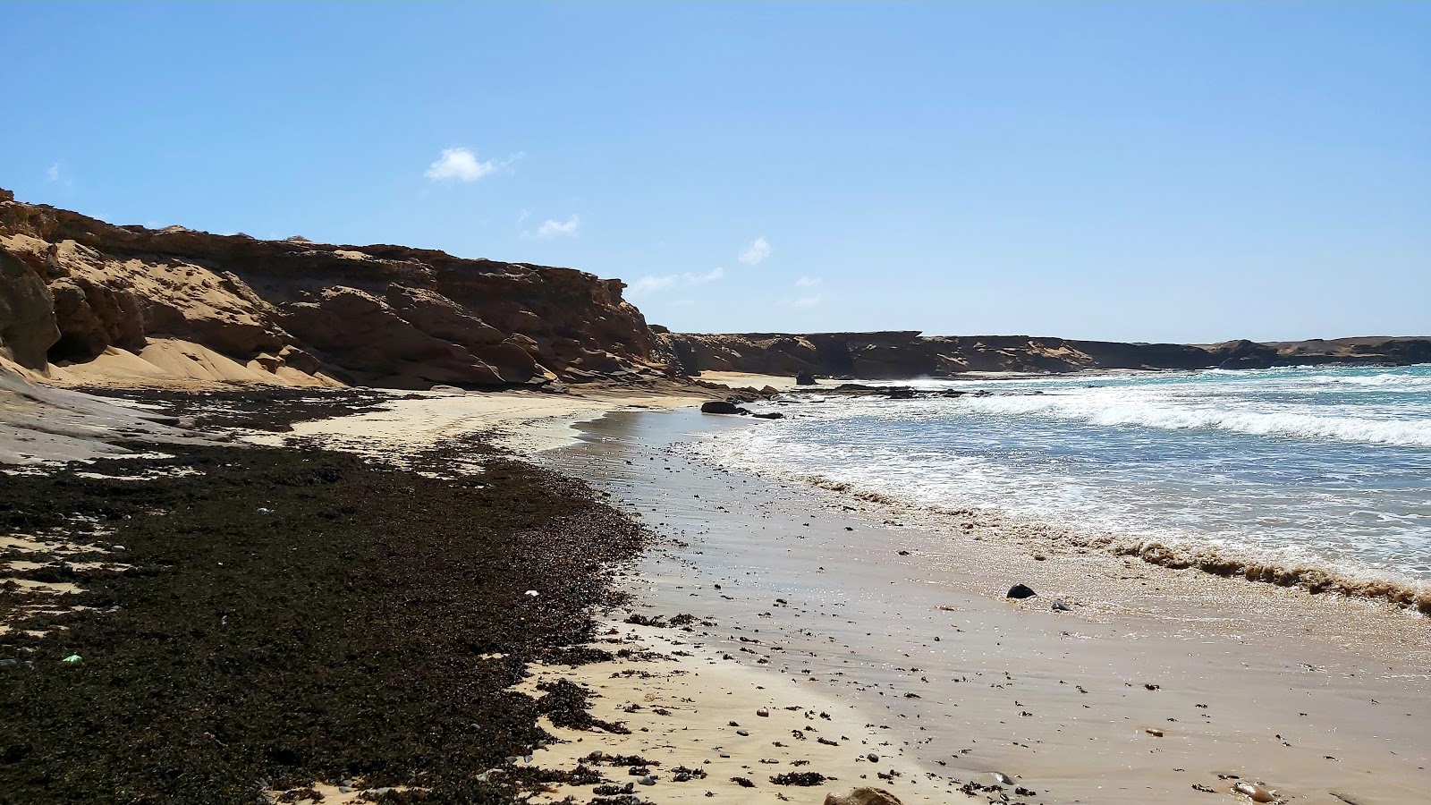 Photo de Playa de la Turbia avec sable brun avec roches de surface