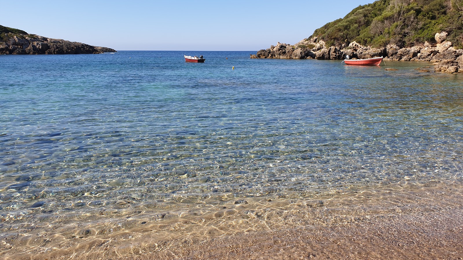 Foto af Vromoneri beach bakket op af klipperne