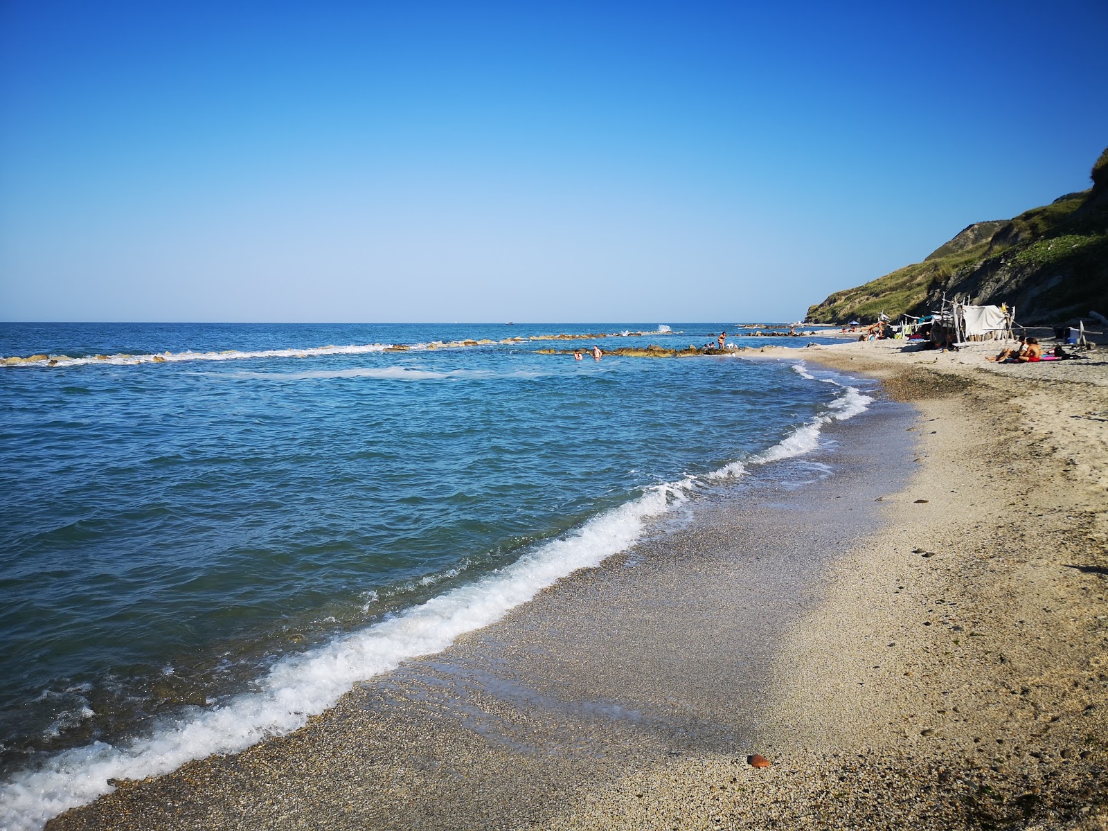 Fotografie cu Spiaggia di Casteldimezzo cu o suprafață de nisip strălucitor și pietre