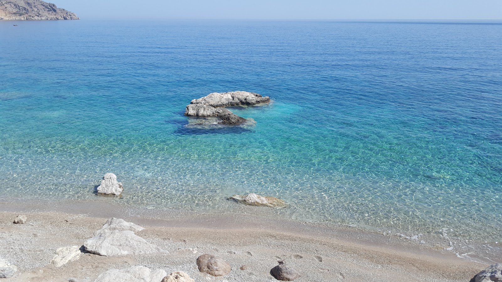 Photo of Evangeline beach with bright sand & rocks surface