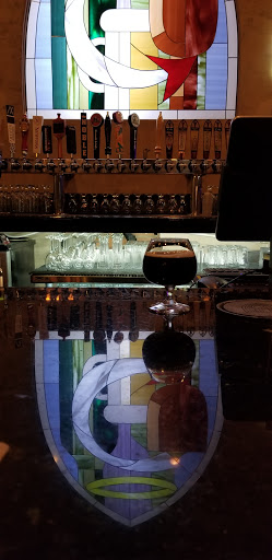 Reflection of coat of arms onto the bar top.  Very cool! Also a glass with Dark of the covenant its brewed in house. 