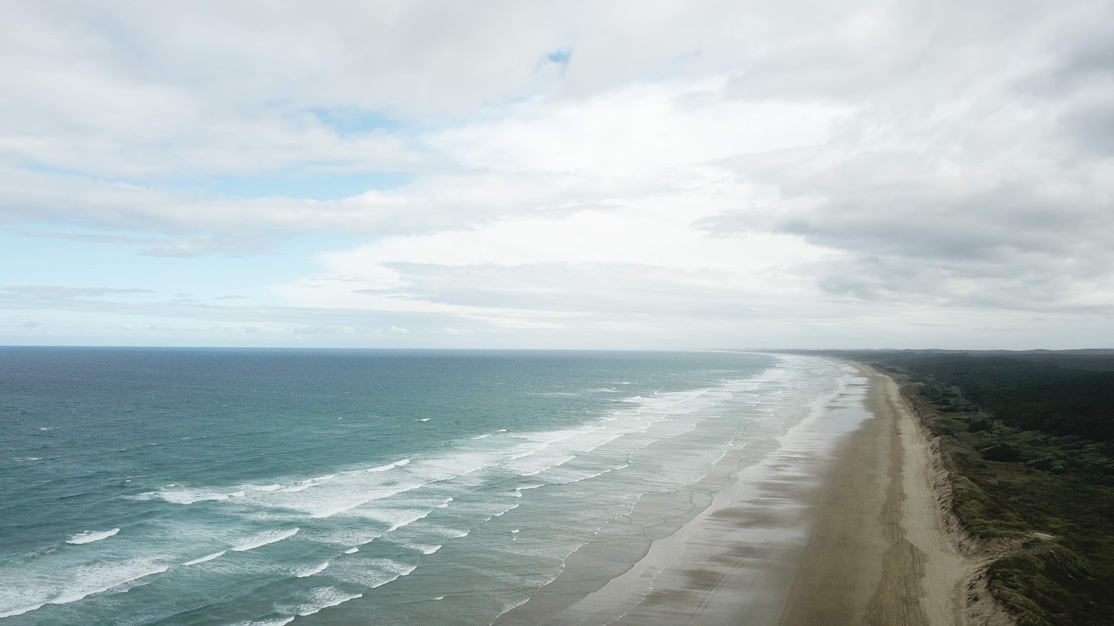 Foto af Ninety Mile Beach Rd bakket op af klipperne