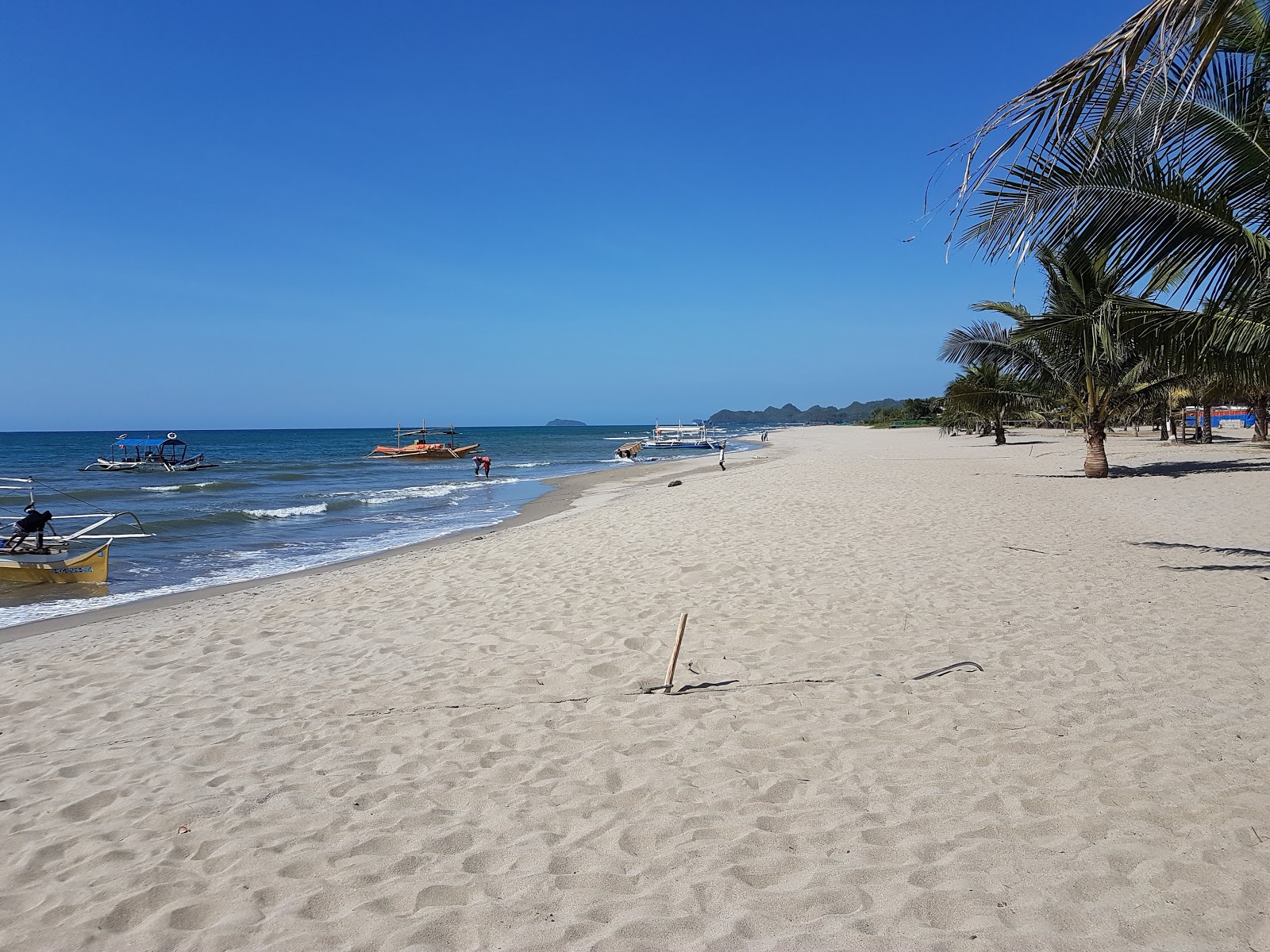 Foto di Poblacion Beach con una superficie del sabbia luminosa